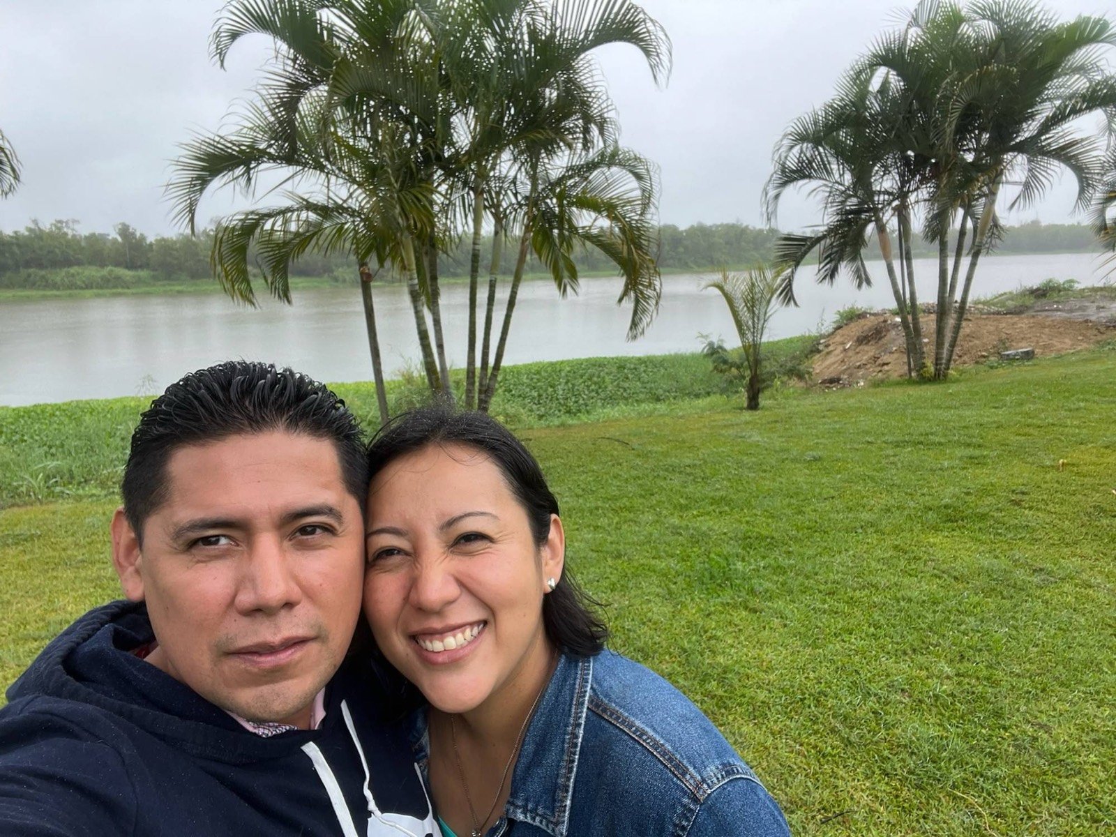 Ofelia y Alberto junto a un río con palmeras